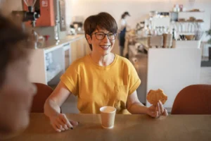 Gambar seorang ibu sedang makan roti dan tersenyum
