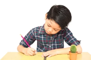 Gambar seorang anak kecil sedang menulis