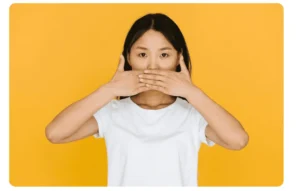 Seorang perempuan sedang menutup mulutnya