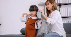 Gambar seorang kakak perempuan sedang memberikan tas kepada adiknya