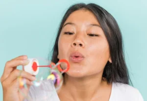 Gambar seorang wanita sedang meniup balon air