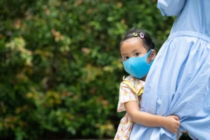 Gambar seorang anak kecil sedang menggunakan masker