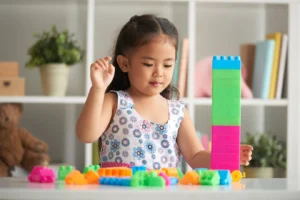 Gambar seorang anak kecil perempuan sedang bermain mainan