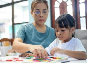 Gambar terapis wicara anak sedang mendampingi anak perempuan selama sesi terapi - Wicaraku